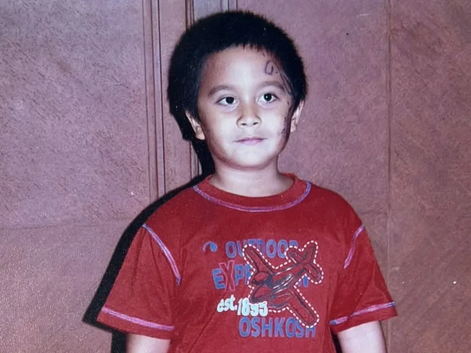 Cole as a child in a red T-shirt